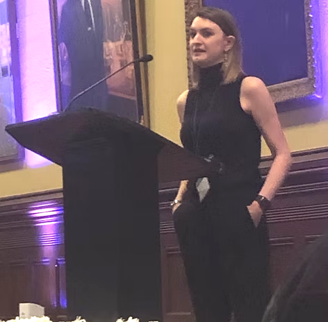 Danielle speaking from a lectern at the Association of Migraine Disorders Awards Dinner