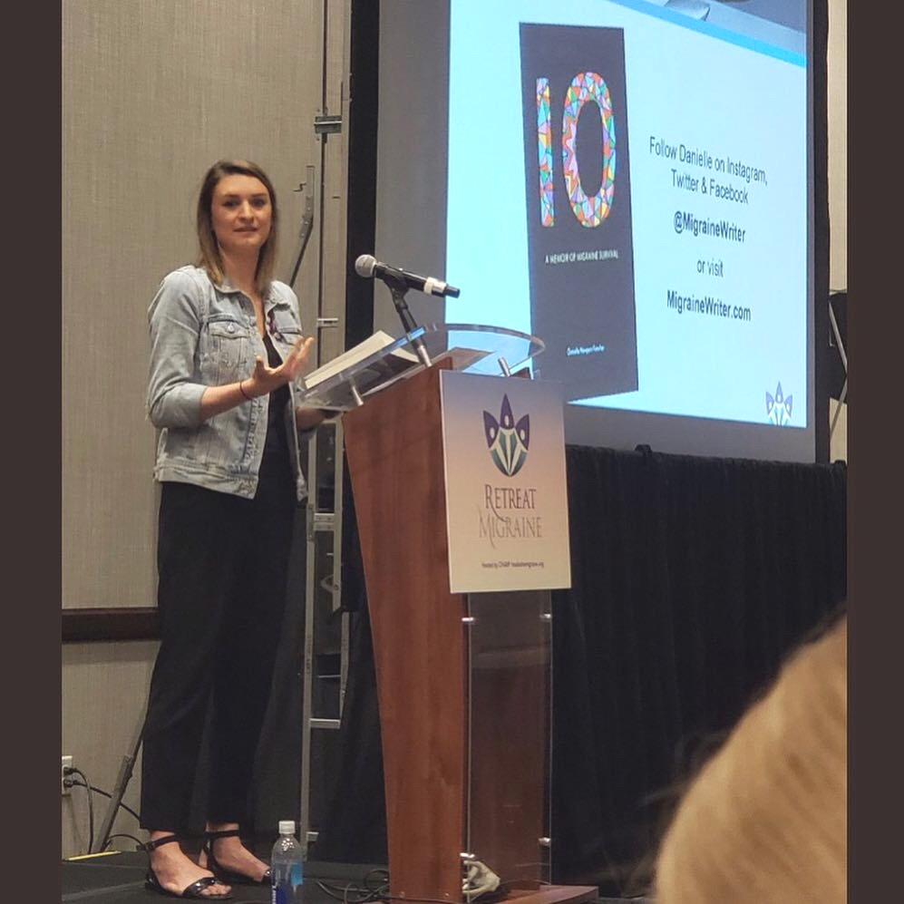 Danielle Newport Fancher speaking from a podium at Retreat Migraine, the cover of 10 projected on the screen behind her