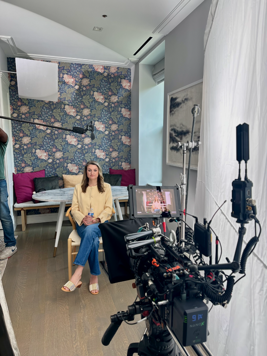 Danielle Newport Fancher seated for a filmed interview, camera rig, boom mic and lighting set up around her