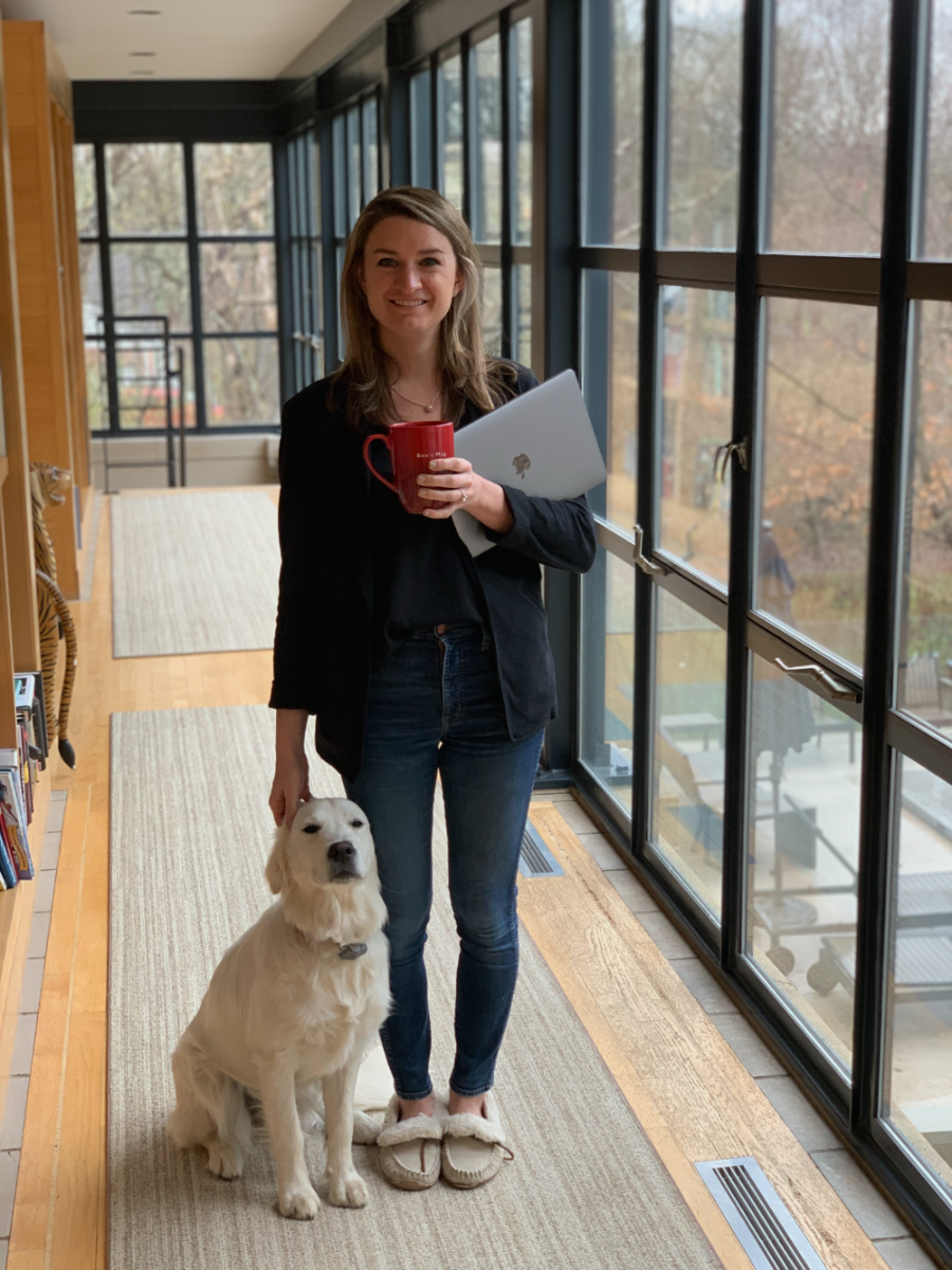 Danielle Newport Fancher at home with her laptop and a mug, her dog beside her, dressed for a virtual Headache on the Hill