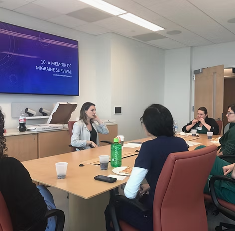 Danielle in conversation with clinicians around a table